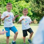 Joyful kids engaging in playful activities in a sunny park, enjoying summer fun together.